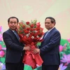 Thủ tướng Phạm Minh Chính tặng hoa chúc mừng quyền Bộ trưởng Bộ Nông nghiệp và Môi trường Trần Đức Thắng. (Ảnh: Hoàng Hiếu/TTXVN)