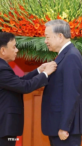 Đồng chí Trần Cẩm Tú, Ủy viên Bộ Chính trị, Thường trực Ban Bí thư trao Huy hiệu Đảng và tặng hoa chúc mừng Tổng Bí thư Tô Lâm. (Ảnh: Thống Nhất/TTXVN)
