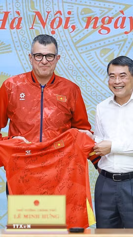 Đại diện đội tuyển bóng đá nam U17 Quốc gia Việt Nam tặng áo thi đấu và bóng cho Thủ tướng Lê Minh Hưng. (Ảnh: Dương Giang/TTXVN)