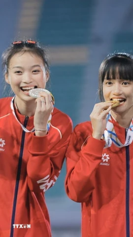 Trần Thị Loan (phải) giành HCV nội dung nhảy xa nữ cùng Hà Thị Thuý Hằng giành HCB trên bục nhận huy chương. (Ảnh: Minh Quyết/TTXVN)