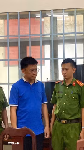 Cơ quan chức năng tống đạt quyết định khởi tố, bắt tạm giam đối với Nguyễn Anh Tiến. (Ảnh: TTXVN phát)
