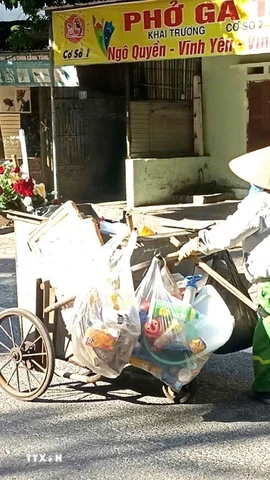 Người lao công quét đường từ sớm nhưng vẫn không tránh được ánh mặt trời gay gắt ngày hè nắng gắt. Ảnh chụp tại đường Chùa Hà phường Vĩnh Phúc, tỉnh Phú Thọ. (Ảnh: Hoàng Hùng/TTXVN)