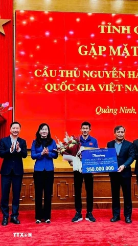 Bí thư Tỉnh ủy Vũ Đại Thắng và lãnh đạo tỉnh Quảng Ninh tặng hoa, tiền thưởng 350 triệu đồng cho cầu thủ Nguyễn Hai Long (từ nguồn ngân sách địa phương và xã hội hóa). (Ảnh: Thanh Tùng/TTXVN phát)