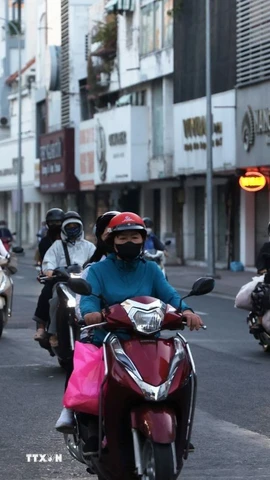 Người dân trong trang phục giữ ấm đi làm trên đường Hồ Văn Huê (phường Đức Nhuận) thời điểm 6 giờ 20 phút sáng 9/1/2026. (Ảnh: Hồng Đạt/TTXVN)