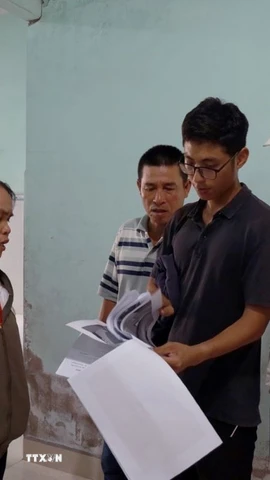 Người dân đối chiếu vết nứt được khảo sát trước thi công và hiện tại để có cơ sở giám định bồi thường thiệt hại. (Ảnh: Xuân Triệu/TTXVN)