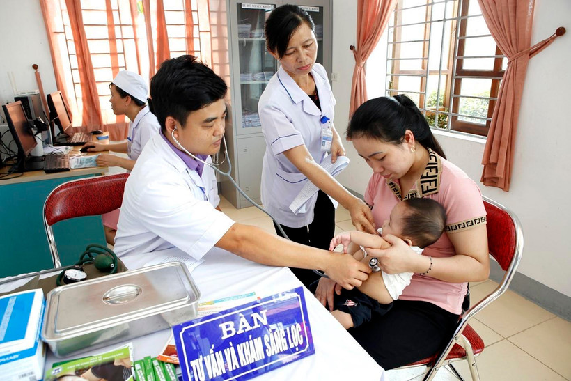 Nhân viên y tế khám sàng lọc trước khi tiêm chủng cho trẻ. (Ảnh: Dương Ngọc/TTXVN)