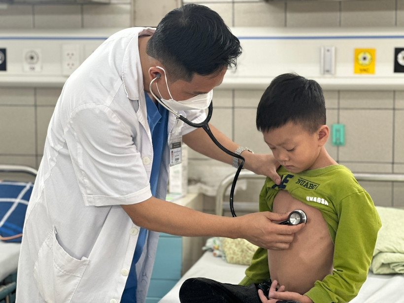 Bác sĩ Trung tâm Nhi khoa (Bệnh viện Bạch Mai) khám, theo dõi sức khỏe cho một bệnh nhi. (Ảnh: T.G/Vietnam+)