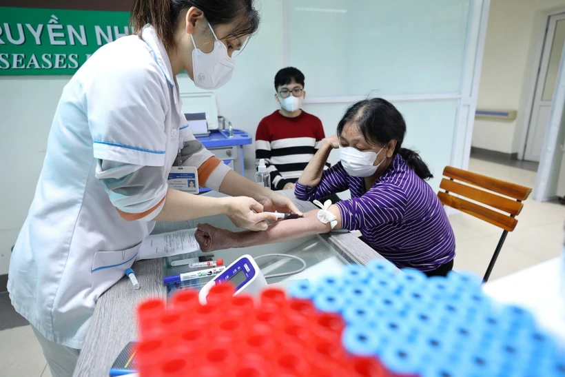 Nhân viên y tế lấy mẫu máu xét nghiệm cho bệnh nhân. (Ảnh: Minh Quyết/TTXVN)