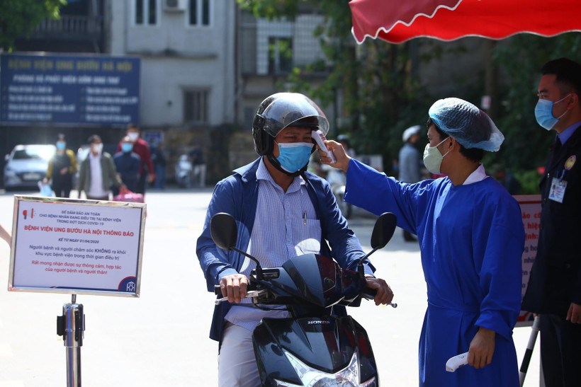 Đo thân nhiệt cho người dân. (Ảnh: Minh Quyết/TTXVN)