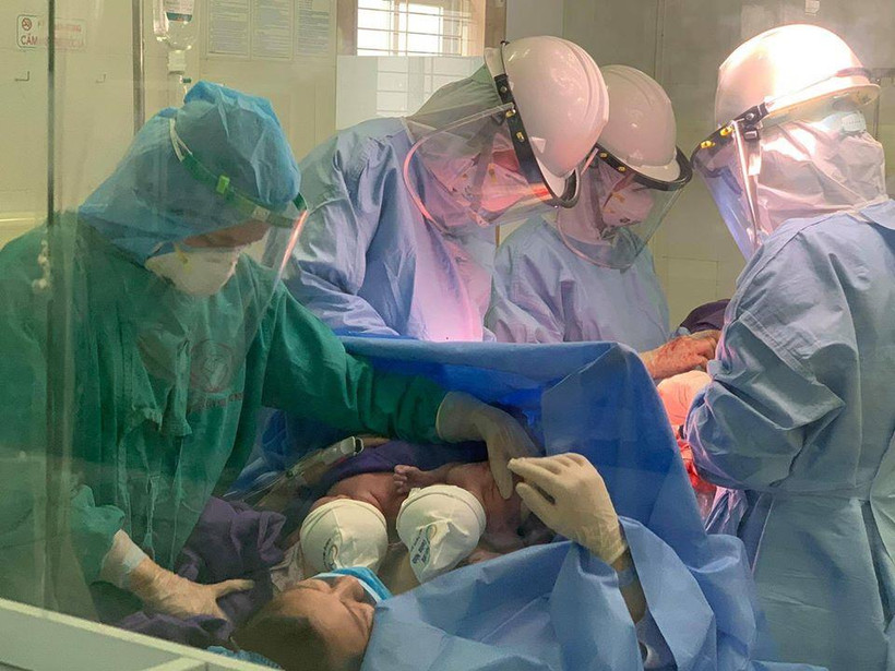 Các bác sỹ thực hiện ca mổ cho sản phụ trong phòng cách ly. (Ảnh: PV/Vietnam+)