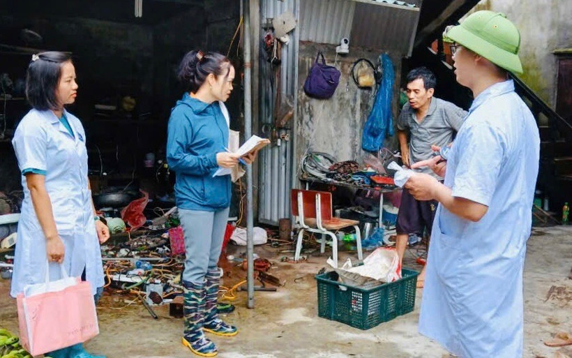 Cán bộ y tế Trung tâm Y tế huyện Ứng Hòa tư vấn, hướng dẫn người dân cách phòng bệnh sau mưa. (Ảnh: PV/Vietnam+)