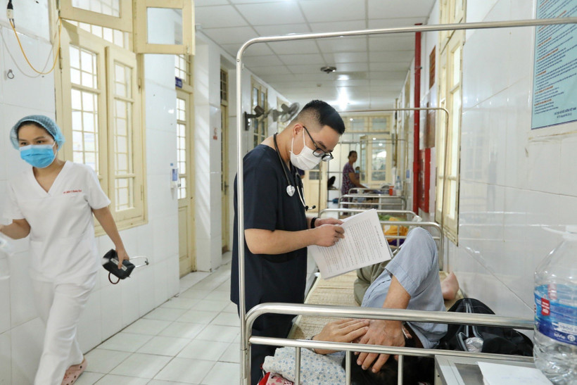 Bác sỹ theo dõi tình hình sức khỏe cho một bệnh nhân mắc sốt xuất huyết tại Hà Nội. (Ảnh: Minh Quyết/TTXVN)