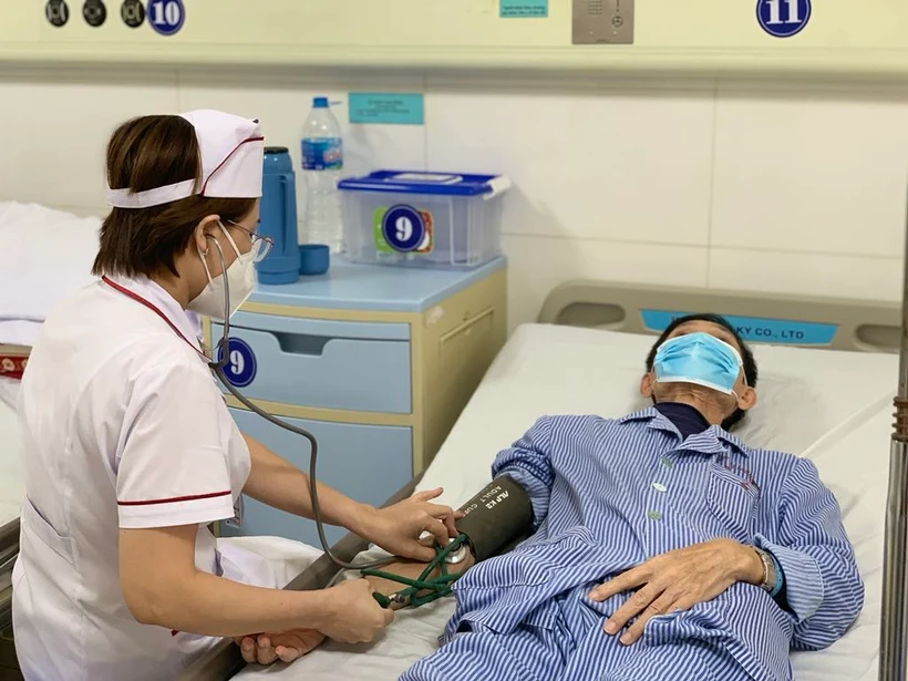 Nhân viên y tế Bệnh viện Phổi Trung ương theo dõi sức khỏe cho một bệnh nhân mắc lao. (Ảnh: PV/Vietnam+)
