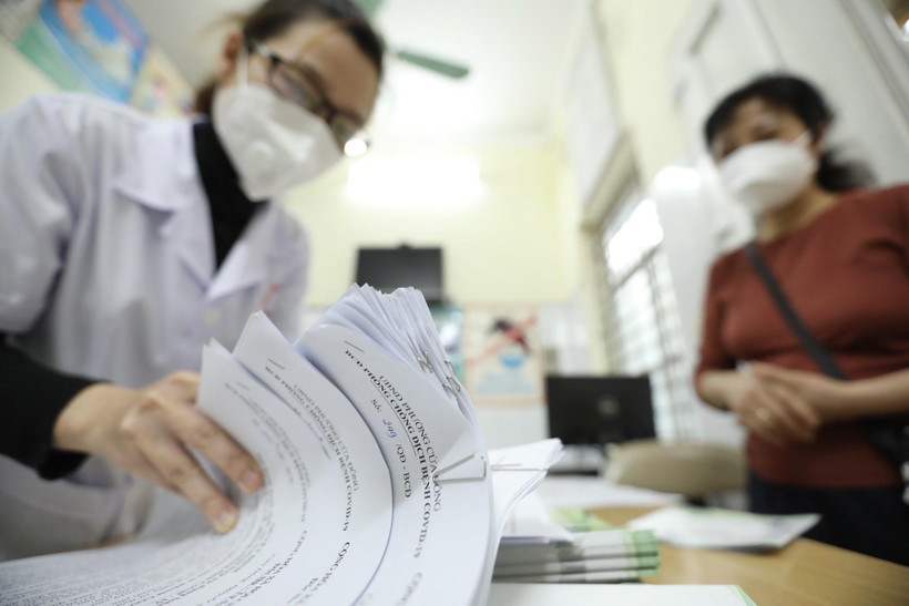 Giấy chứng nhận khỏi bệnh được trạm y tế phường thông báo cho tổ trưởng tổ dân phố đến nhận và phát cho các bệnh nhân F0 khỏi bệnh. (Ảnh: Minh Quyết/TTXVN)