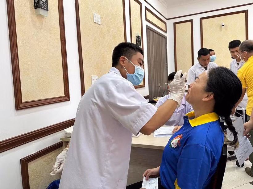 Nhân viên y tế xét nghiệm COVID-19 cho người dân. (Ảnh: Thùy Giang/Vietnam+)