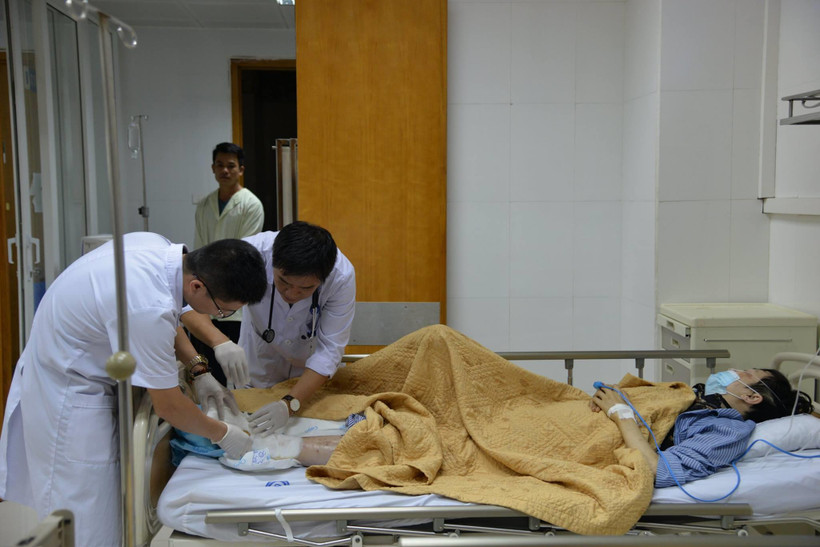 Các bác sỹ kiểm tra vết thương ở chân cho bệnh nhân. (Ảnh: PV/Vietnam+)