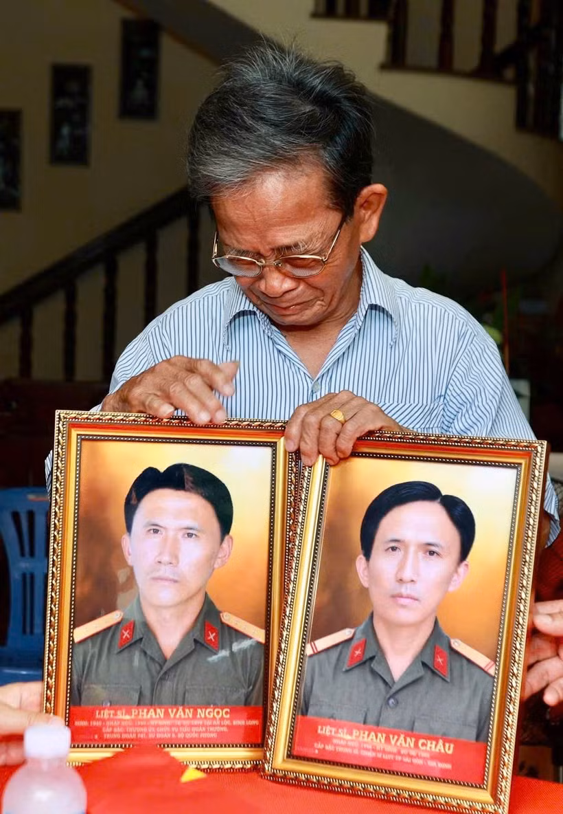 Ông Phan Văn Tư bên tấm di ảnh người anh trai của ông là liệt sĩ Phan Văn Ngọc và Phan Văn Châu - những người đã ngã xuống khi tuổi đời còn rất trẻ. (Ảnh: Bộ Tư lệnh Thành phố Hồ Chí Minh cung cấp)