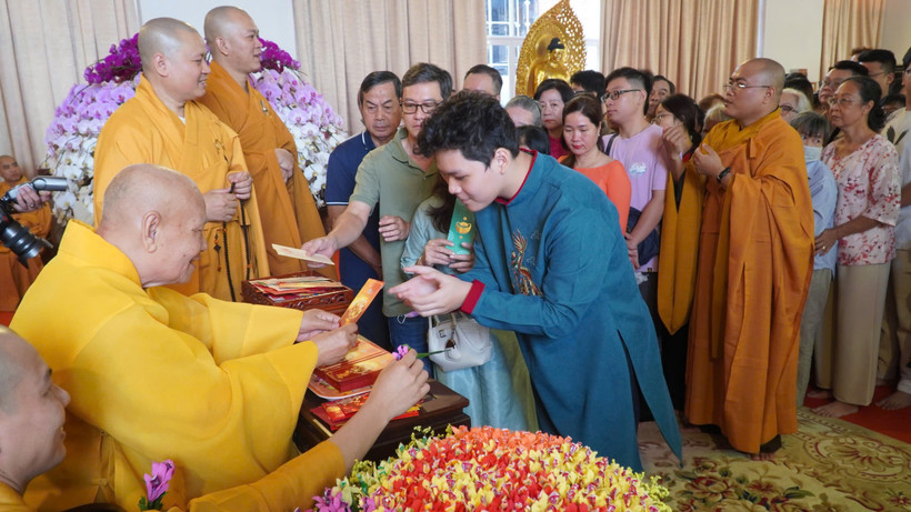 Trưởng lão Hòa thượng Thích Thiện Nhơn – Phó Pháp chủ Hội đồng Chứng minh, Chủ tịch Hội đồng Trị sự Giáo hội Phật giáo Việt Nam lì xì năm mới cho các phật tử đến Chùa Minh Đạo. (Ảnh: Khánh Ly/Vietnam+)