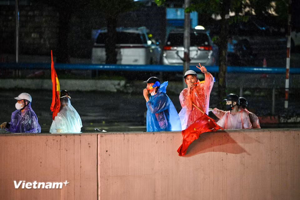 Trên nhiều tuyến phố, những lá cờ đỏ sao vàng tung bay giữa dòng người. Các nhóm cổ động viên liên tục hô vang “Việt Nam vô địch” tạo nên những màn ăn mừng sôi động. (Ảnh: Minh Sơn/Vietnam+)