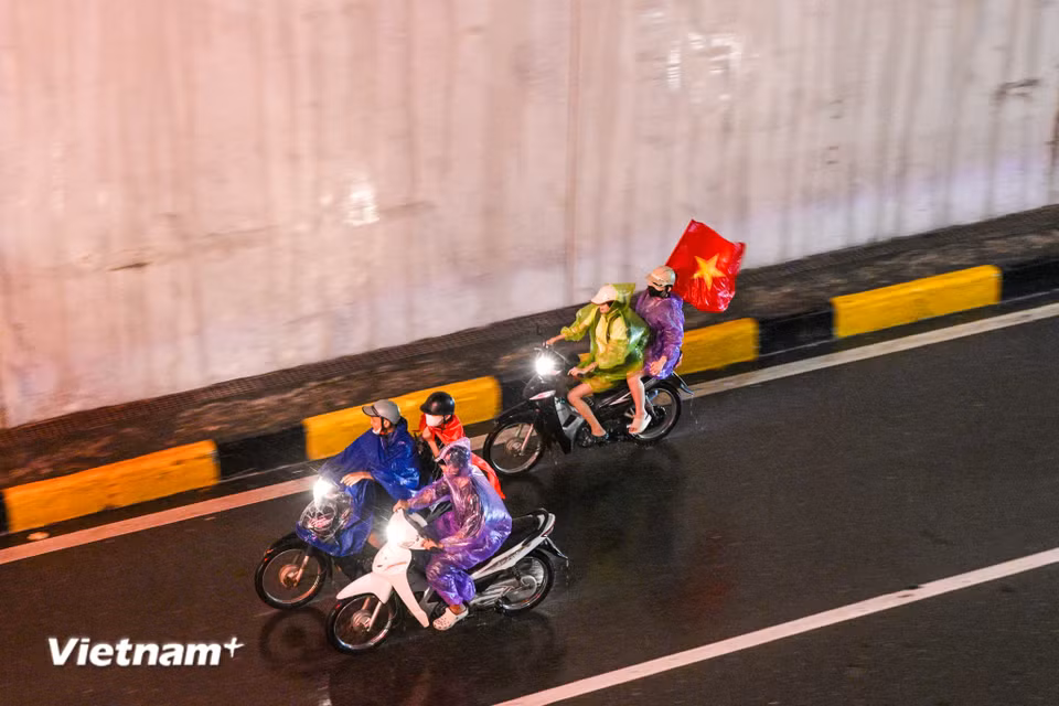 Những cơn mưa bất chợt không thể ngăn bước chân người hâm mộ. (Ảnh: Minh Sơn/Vietnam+)