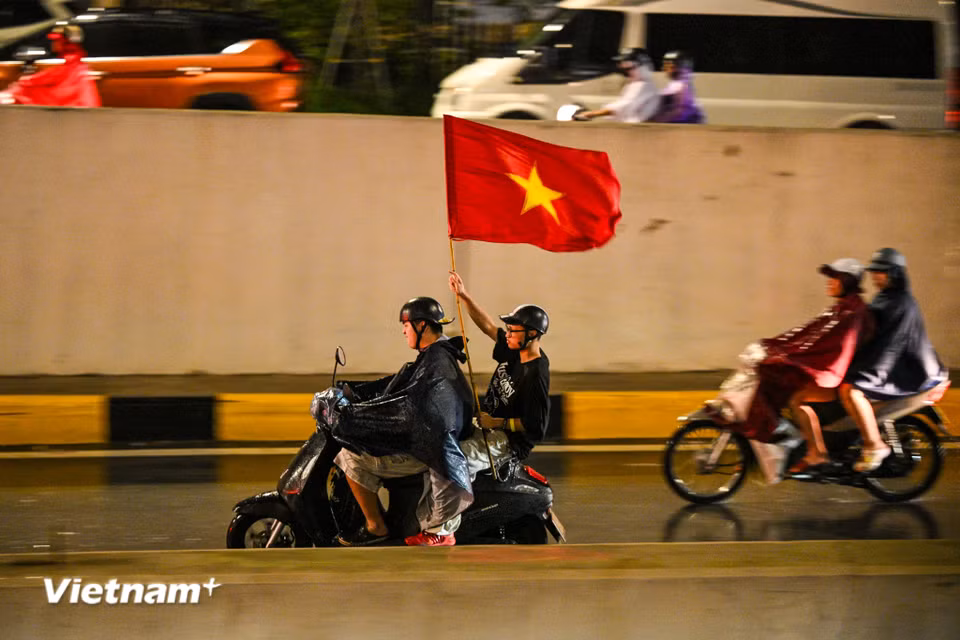 Khu vực Hầm Kim Liên - Đại Cồ Việt hàng nghìn người cầm cờ reo hò sau chiến thắng của đội tuyển Việt Nam. (Ảnh: Minh Sơn/Vietnam+)