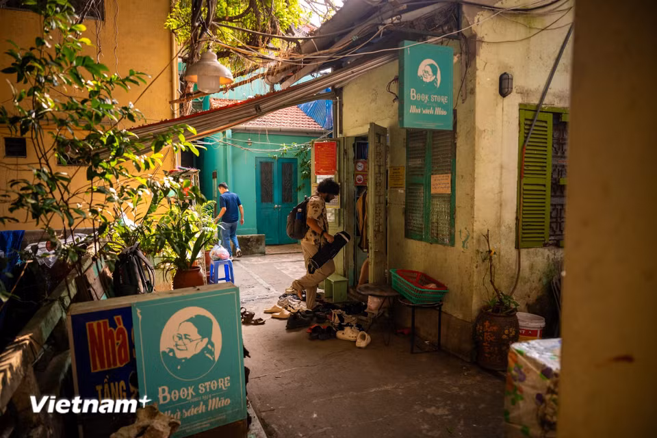 Trong những địa chỉ gắn bó với lịch sử phố sách Đinh Lễ, nhà sách Mão là cái tên được nhiều người mê sách nhắc nhớ. Nằm trên căn gác hai của khu tập thể cũ trong ngõ số 5 Đinh Lễ, nhà sách không phô bày sự hiện đại hay rộng lớn ngay từ bên ngoài. Lối vào nhỏ, những bậc cầu thang dẫn lên không gian chứa đầy sách tạo cảm giác như bước vào một không gian khác của Thủ đô. (Ảnh: Minh Sơn/Vietnam+)