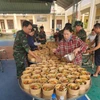 Cục Hậu cần – Kỹ thuật Quân khu 5 tổ chức nấu, cấp phát suất ăn, nước uống, thuốc men hỗ trợ người dân ở vùng ngập sâu. (Ảnh: PV/Vietnam+)