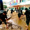 Cán bộ, chiến sỹ Cục Hậu cần - Kỹ thuật Quân khu 5 hỗ trợ một trong tiểu học trên địa bàn xã Nông Sơn dọn bùn non sau khi nước rút. (Ảnh: PV/Vietnam+)