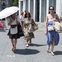 Người dân di chuyển dưới trời nắng gay gắt tại Madrid, Tây Ban Nha. (Ảnh: THX/TTXVN)