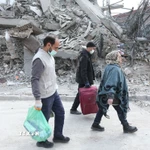 Người dân đi qua đống đổ nát của những tòa nhà bị phá hủy tại Tehran, Iran. (Ảnh: THX/TTXVN)