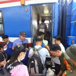 Hành khách xếp hàng lên tàu. (Ảnh: Lê Xuân/TTXVN)