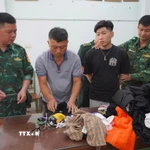 Cán bộ Đồn Biên phòng Mỹ Quý Tây kiểm tra đối tượng cùng tang vật. (Ảnh: TTXVN phát)