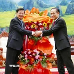 Đặc phái viên của Tổng Bí thư Tô Lâm, ông Lê Hoài Trung chúc mừng Tổng Bí thư Ban Chấp hành Trung ương Đảng Nhân dân cách mạng Lào khóa XII, Chủ tịch nước Lào Thongloun Sisoulith. (Ảnh: Xuân Tú/TTXVN)