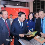 Trưởng Ban Tuyên giáo và Dân vận Trung ương Trịnh Văn Quyết cùng các đại biểu tham quan khu trưng bày sách đoạt giải. (Ảnh: Phan Phương/TTXVN)