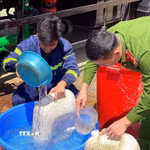 Các chiến sỹ Phòng cháy chữa cháy cùng Công an xã Pà Cò hỗ trợ phân phát nước cho người dân địa phương. (Ảnh: Thanh Hải/TTXVN)