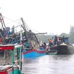 Lực lượng Bộ đội Biên phòng, các lực lượng, chính quyền địa phương và người dân nỗ lực kéo tàu lên khỏi vị trí chìm. (Ảnh: TTXVN phát)