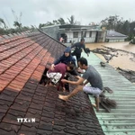 Lũ dâng cao, người dân phải phá mái nhà leo lên để tránh nguy hiểm ở Gia Lai. (Ảnh: TTXVN phát)