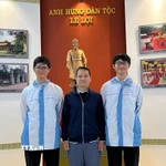 Thầy giáo Bùi Văn Bình, giáo viên môn Toán Trường THPT chuyên Lam Sơn chụp ảnh cùng Phúc Khánh (bên trái) và Vĩnh Kỳ. (Ảnh: TTXVN phát)