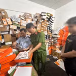 Công an thành phố Cần Thơ phối hợp Chi Cục quản lý thị trường thành phố kiểm đếm số quần áo “giả” thương hiệu nổi tiếng tại cửa hàng T.H Luxury. (Ảnh: TTXVN phát)