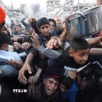 Người dân chờ được phát thực phẩm cứu trợ tại Gaza. (Ảnh: THX/TTXVN)
