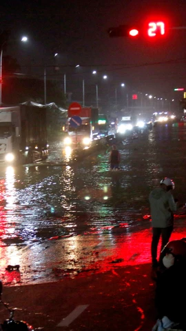 Quốc lộ 1A, đoạn qua phường Hàm Thắng (Lâm Đồng) bị ngập sâu, các phương tiện lưu thông khó khăn. (Ảnh: Nguyễn Thanh/TTXVN)