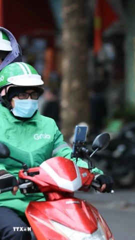 Người dân che chắn chống rét khi phải di chuyển trên đường. (Ảnh: Hoàng Hiếu/TTXVN)