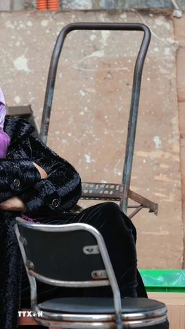 Một người bán hàng co ro trong tiết trời lạnh. (Ảnh: Hoàng Hiếu/TTXVN)