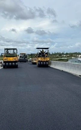 Nhà thầu huy động máy móc thi công thảm nhựa nền đường. (Ảnh: Việt Hùng/Vietnam+)