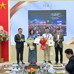 Tổng Biên tập Báo Nhân Dân Lê Quốc Minh và Phó Chủ tịch thường trực Hội Nhà báo Việt Nam Nguyễn Đức Lợi trao giải A cho các tác giả. (Ảnh: CTV/Vietnam+)