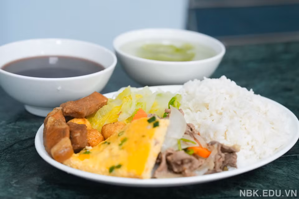 Bữa cơm tối của các em học sinh đầy đủ như bữa ăn bán trú. (Ảnh: Nhà trường cung cấp/Vietnam+)