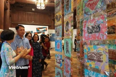 Ông Lê Xuân Kiêu, Giám đốc Trung tâm Hoạt động Văn hóa Khoa học Văn Miếu-Quốc Tử Giám cùng các họa sỹ tham quan triển lãm. (Ảnh: Minh Thu/Vietnam+)