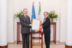 Đại sứ Marco della Seta trao Huân chương Công trạng của Chính phủ Italy cho ông Greig Craft. (Ảnh: PV/Vietnam+)
