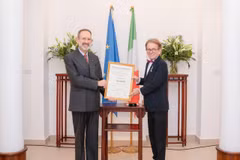 Đại sứ Marco della Seta trao Huân chương Công trạng của Chính phủ Italy cho ông Greig Craft. (Ảnh: PV/Vietnam+)