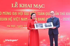 Giám đốc Khu Di tích Chủ tịch Hồ Chí Minh tại Phủ Chủ tịch Lê Thị Phượng tiếp nhận hiện vật từ Đại sứ Liên bang Nga Gennady S. Bezdetko. (Ảnh: PV/Vietnam+)